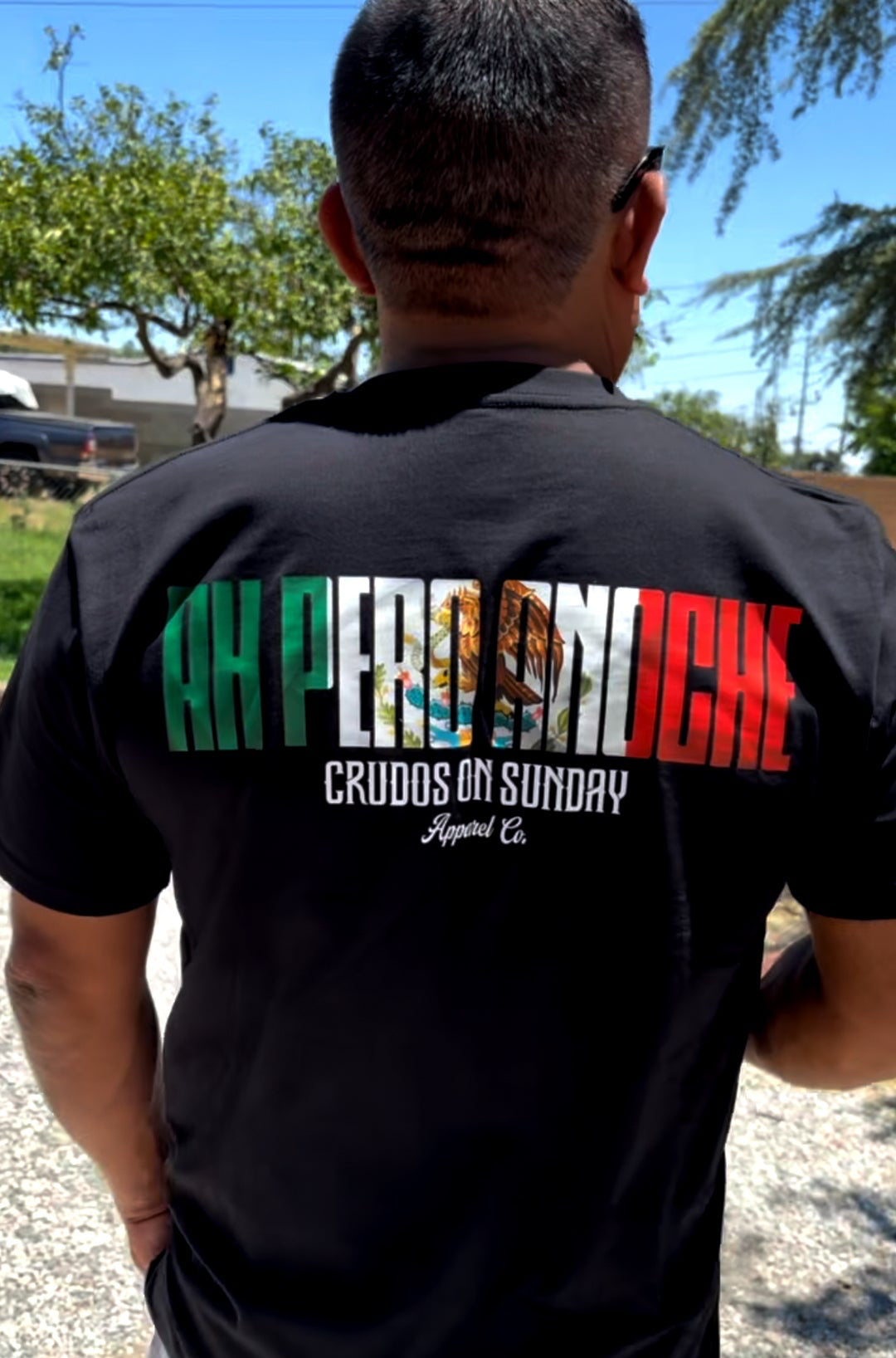 Black t-shirt with "Ah Pero Anoche" in bold gothic letters filled with Mexican flag colors from Crudos on Sunday streetwear